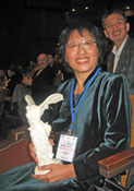 Photo of Dr. Liu Chuang receiving the 2008 CODATA Prize, symbolized by a reproduction of the Louvre's Winged Victory of Samothrace.